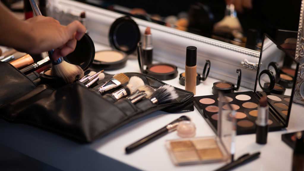 Berbagai jenis alat make-up di atas meja.